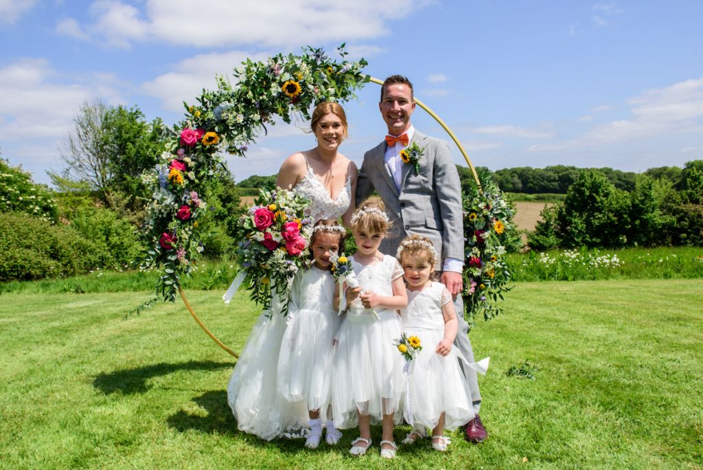 Bride and Groom with flower girls on the meadow at Monkton Barn