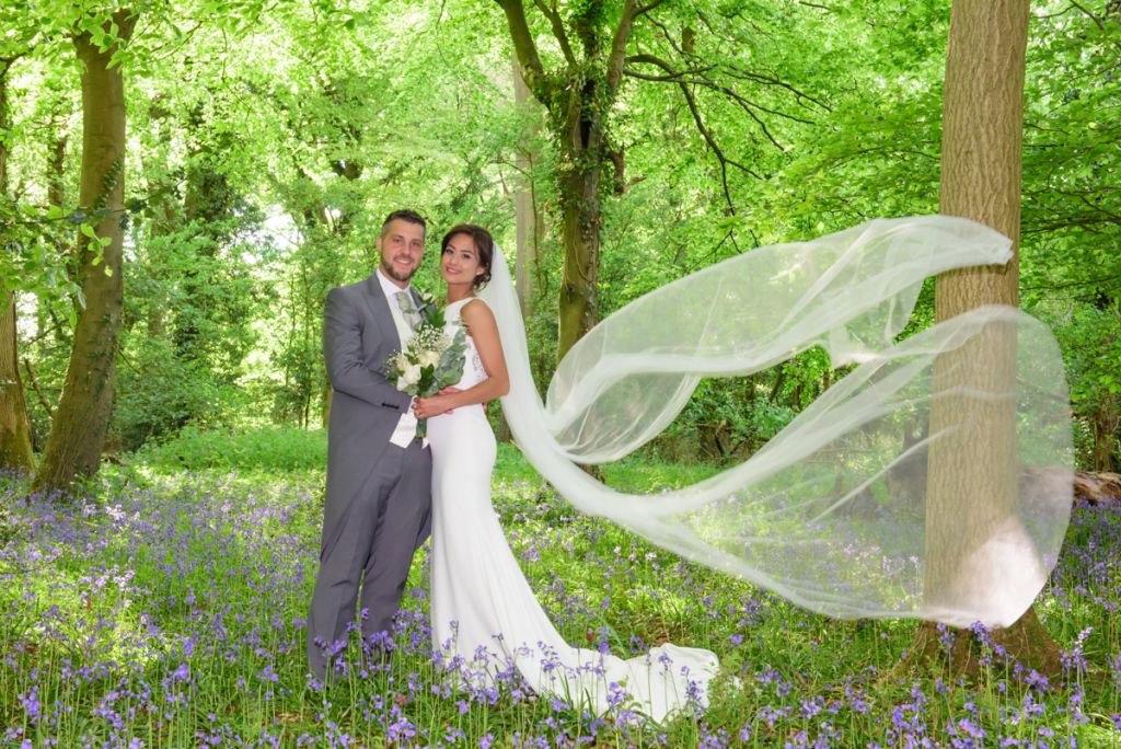Bride and Groom in bluebell woods at Monkton Barn